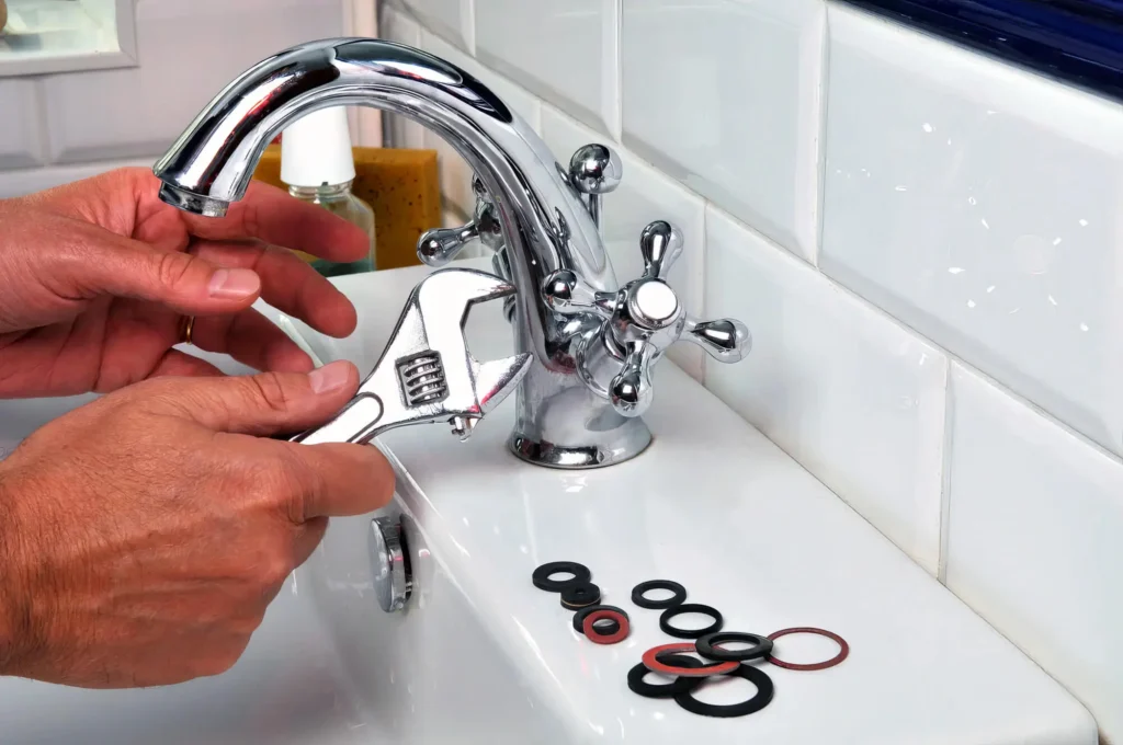 Plumber performing maintenance on a bathroom faucet in Brighton