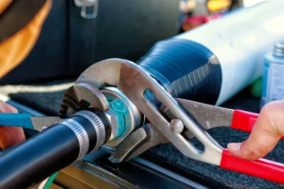Technician tightening an industrial pipe connection in Brighton