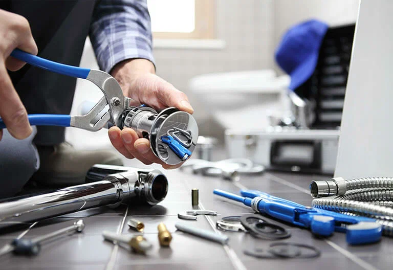 Technician repairing a plumbing fixture with professional tools in Brighton