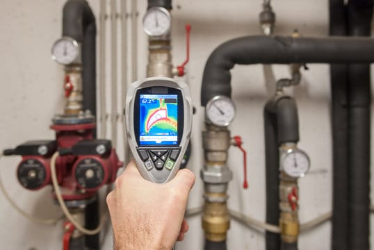 Plumber using a thermal imaging camera to inspect pipes in Brighton