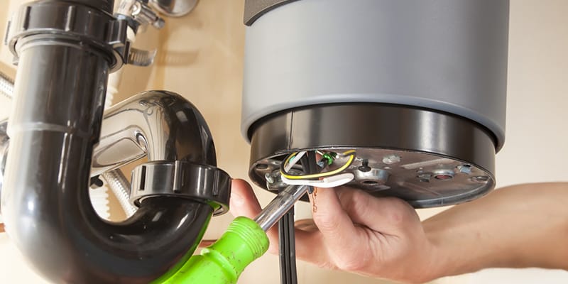 Technician repairing the heating element of a water heater in Brighton