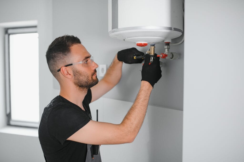 Technician performing water heater maintenance in Brighton